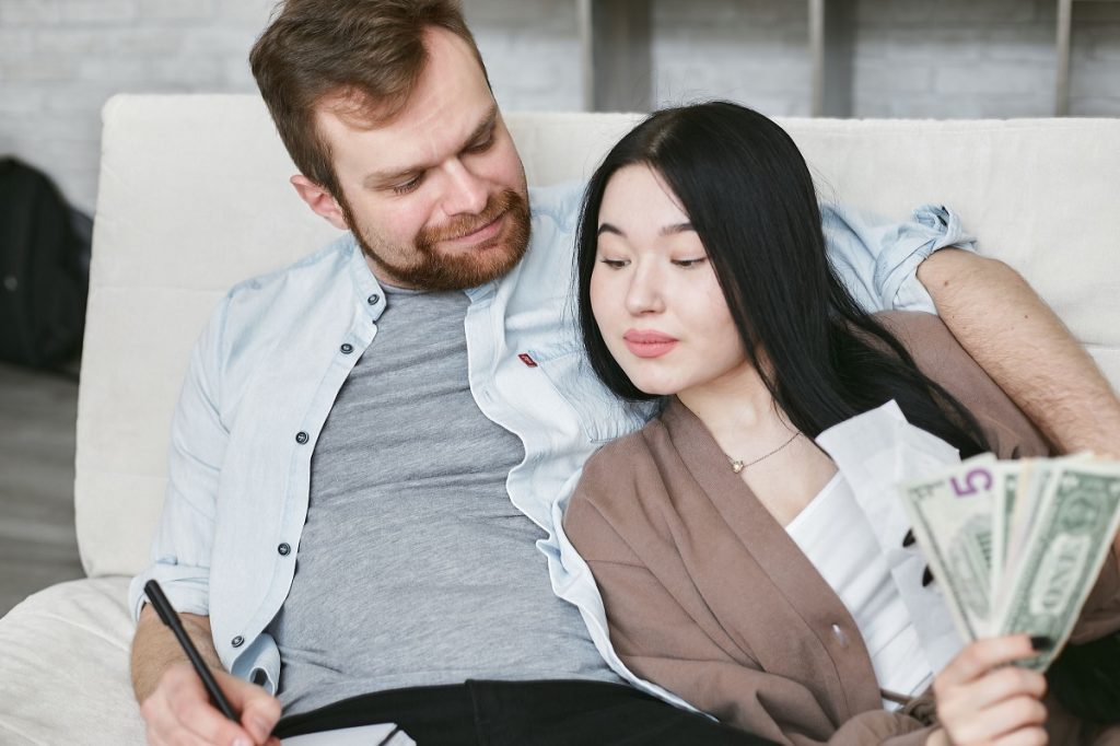 couple sitting on a couch, planning their finances