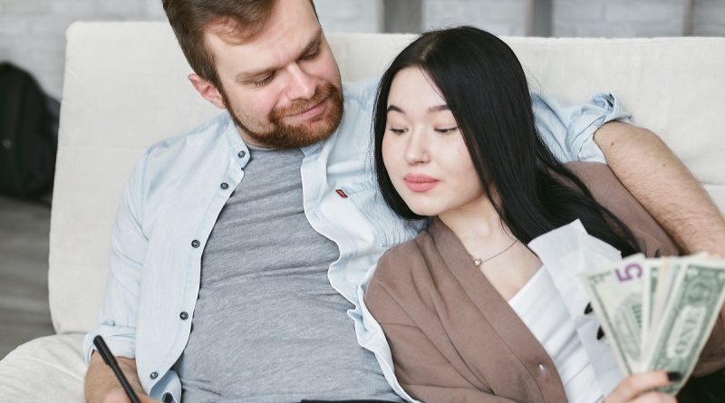 couple sitting on a couch, planning their finances